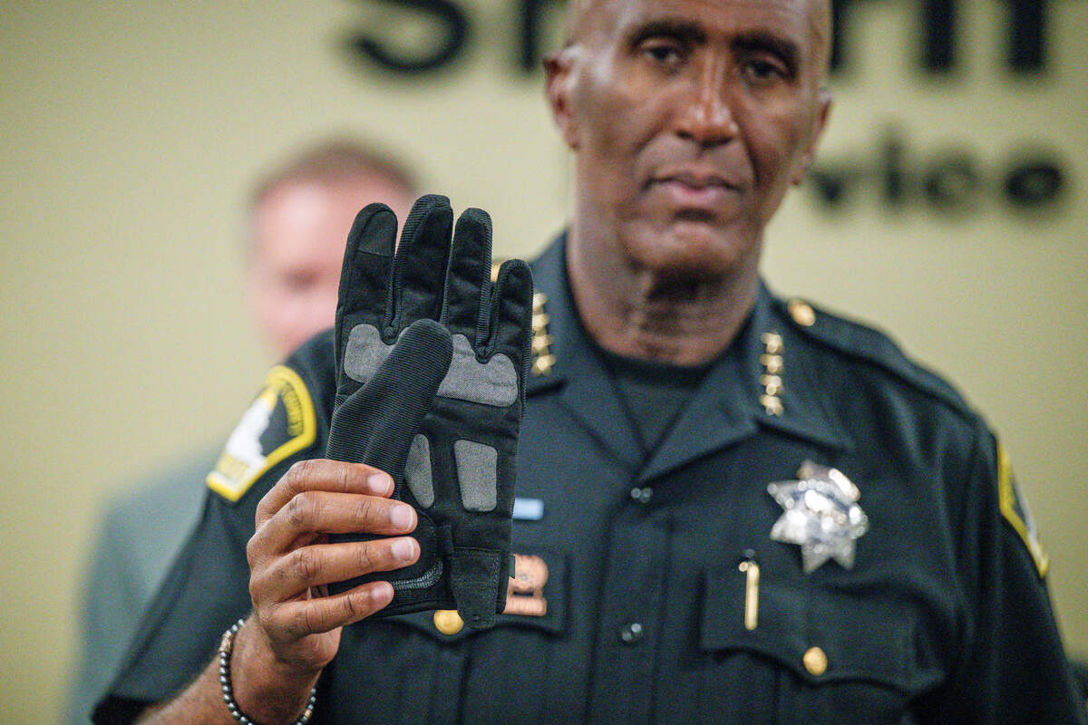 Sacramento County Sheriff Jim Cooper displays an electric shock glove during a news conference at the Sheriff’s Office Headquarters on Thursday.